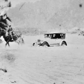 Car being towed across the Punakaiki River by horsepower.