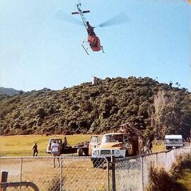 Westpower workers flying drums of gravel into pole sites, Greymouth.1980.