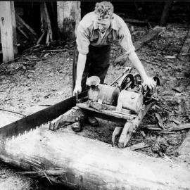 Timber worker using a motorised saw at Granite Creek near Kongahu,Karamea.1941.