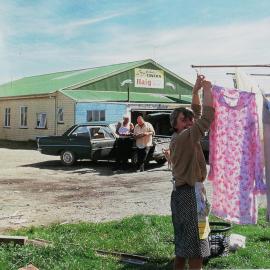 Coral Webster hangs out the washing - Gordon talks with Ken Norton, outside the Greyhound Tavern.1980s.