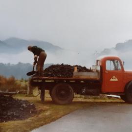Shovelling coal off a truck on Ranfurly Street, Runanga, 1977