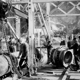The Taramakau Inverted Syphon - Joining pipes before lowering from Pontoon.ca.1912.