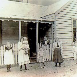 Isabella Aicken holding Florence - Jessie Aicken on front verandah.ca.1899.