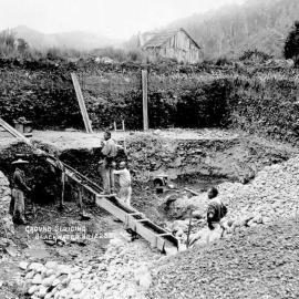 Chinese goldminers  sluicing for gold with a ground sluice,Black Water,Kumara .ca.1915.