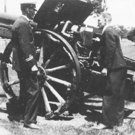 Army Area Officer - Captain Stevens, and Sid Woods inspect the old artillery gun in Victoria Square,Westport.
