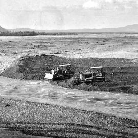 Bluey and Peter Hansen working machinery in changing the Waitangitaona River flow.ca.1968.