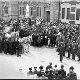 Horse drawn carriage and cars in front of Government Buildings, Hokitika.1900`s.