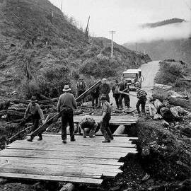 Workers building a temporary bridge across a gap in the road after earthquake. .1929.