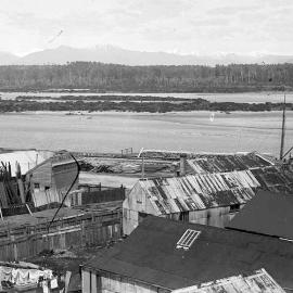 Looking south over the Hokitika River -  J C Malfoy Timber Merchants in the foreground.ca.1900-1909.