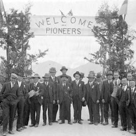 Waiuta's earliest miners pose below a banner erected to welcome them back to town.