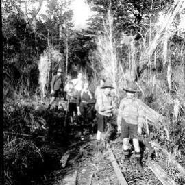 Schoolboy outing, Alice Williams, an unidentified man and children on an unknown forest track,West Coast.ca.1930`s.