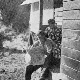 Reading a copy of the Weekly News at a Roadman's home on the Fox Glacier road near Weheka,1937.