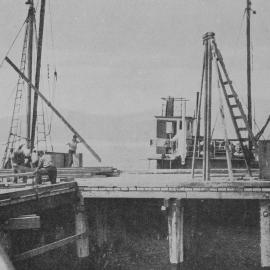 Unloading rails from the small ship Gael, the first vessel to berth at the new wharf being constructed at Jackson Bay.1938.