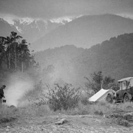 Unidentified man cooking at a campfire , South Westland.ca.1930`.