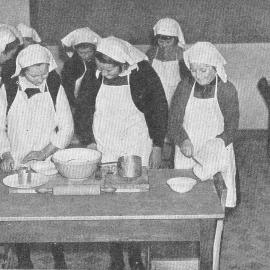 Instruction in homecraft: girls in the kitchen preparing a meal at Westport District High School.1939.