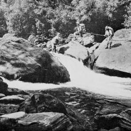 Trampers crossing a difficult ford on the Architect Creek near Copland Pass in Westland.