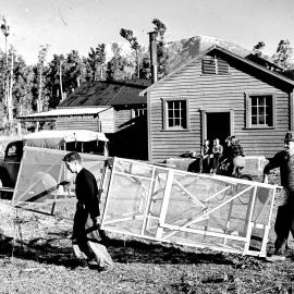Men carrying a whitebaiting frame at Okuru.ca.1940`s.