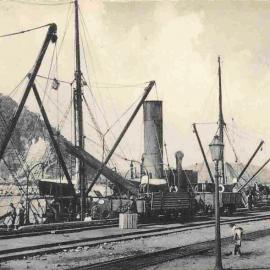LOADING TIMBER. GREYMOUTH PORT. Note the two gas lights in foreground.