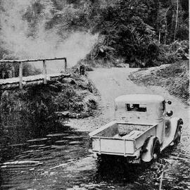A Public Works Department lorry fording Scotts Creek, Karangarua, on the road from Weheka to Bruce Bay.1937.