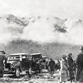 Cars and passengers waiting to be assisted across the river after recent flooding on the West Coast Road, South Island.1924.