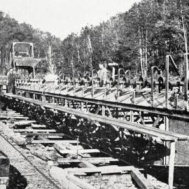   A 90 foot  stacker ladder being constructed to be used for disposing of the tailings at the stern of the dredge - Brian Boru Company's claim being developed near Nelson creek. 1932.