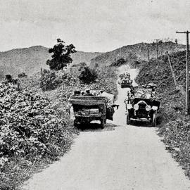 Cars of holidaymakers on the narrow road through the Buller Gorge .1923.