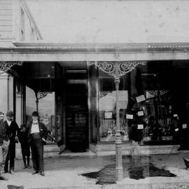 Group of men standing in front of the premises of W Townson, Chemist, in Westport.1900-1909.