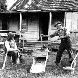  Gold miners in front of their cottage, demonstrating a sluice box.West Coast,1930`s.