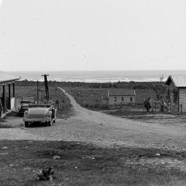  An Auckland Weekly News reporter's car is parked in front of the All Nations Hotel on the left.Barrytown.ca.1930-1939.