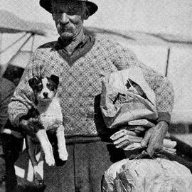  A man holding a puppy in one hand and airmail in the other - Arrivals at Haast on a South Westland Air Service airplane.1936.