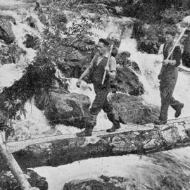 Workers crossing a makeshift bridge  - on the constuction of the Hollyford-Okuru road. 1939.