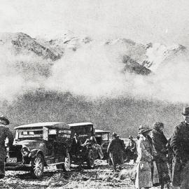 Cars and passengers waiting to be assisted across the river after flooding on the West Coast .1924.