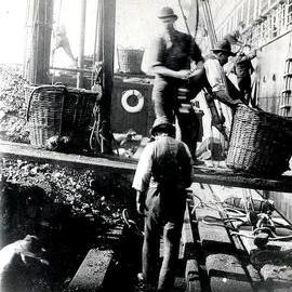 1930 Cane baskets used in coaling -  Westport Coal Co's hulk "Verito" coaling the San Francisco Mail Steamer "Ventura", Auckland.
