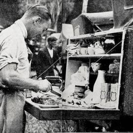  A touring motorist prepares lunch from the back of his car.28 Mar,1929.