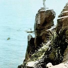 A member of the Auckland Tramping Club standing on top of a rock stack at Pancake Rocks.Punakaiki.1920 -1939.