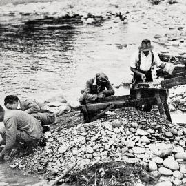 Visitors try their luck at panning for gold at a prospector's claim by the Matakitaki river, near Murchison.1932.