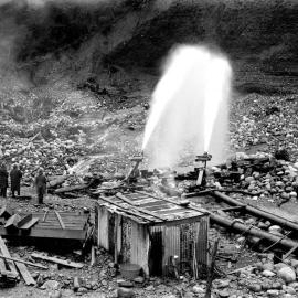Two powerful jets at work during hydraulic operations at the HoHonu Sluicing Company's claim at the Greenstone Creek, between Hokitika and Greymouth.ca.1933.
