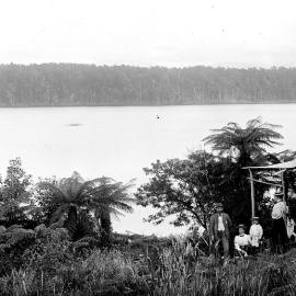 Five people outside a lakeside hut , Westland.ca.1900.