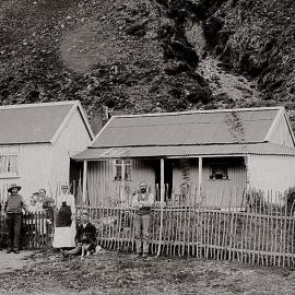 A family outside their corrugated iron homestead, probably located near Otira.