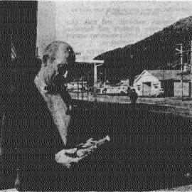 Mr J. Martini, of Harihari, with two bottles of water taken from a natural hot spring near the Wanganui River, 1970