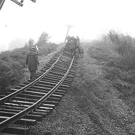  Workers pushing a motor trolley up an uplifted piece of track after the 1968 Inangahua earthquake.