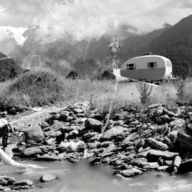 A woman crossing the Tatare Stream at a campsite near Franz Josef Glacier.ca.1950`s.