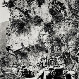 Two cars passing under Hawks Crag.
